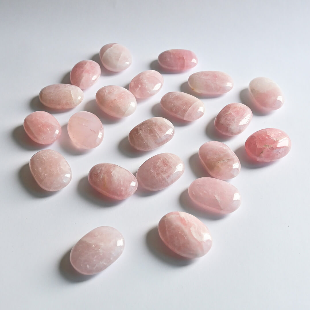 Rose Quartz Palm Stones on white surface