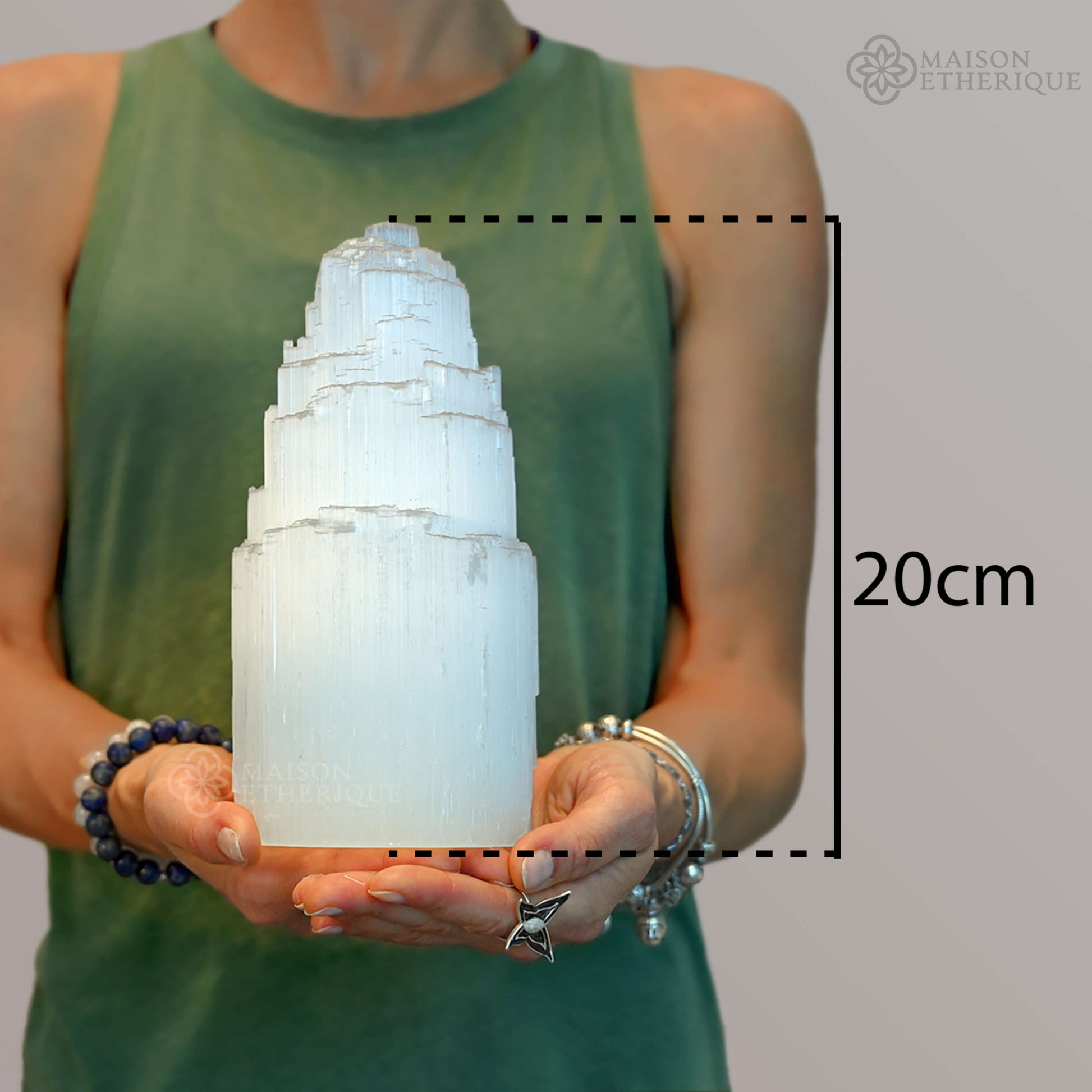 A woman holding A Selenite Crystal Tower - 20cm - 